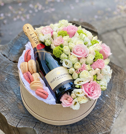 Flowers box with champagne and macaroons